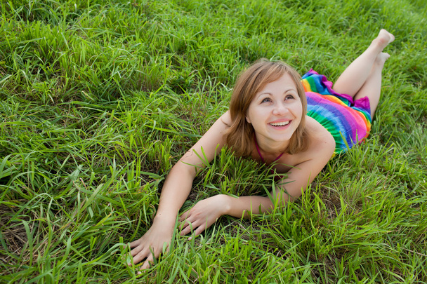 Joyful girl on the grass looking up - Foto, afbeelding