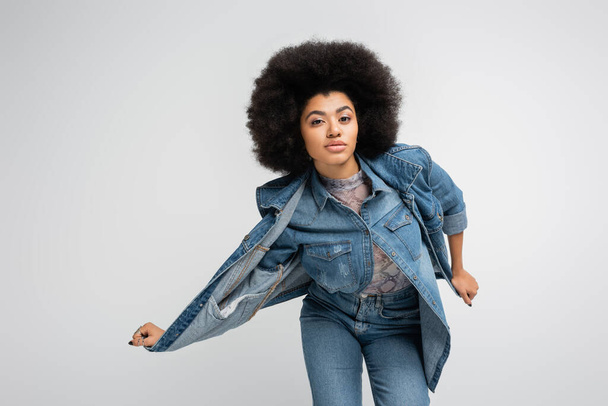 Stylish african american model touching denim vest isolated on grey  - Foto, immagini