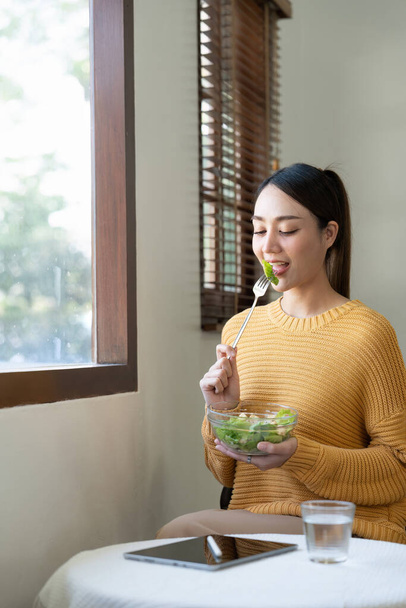 Delighted woman eating food for health at home. - Photo, Image