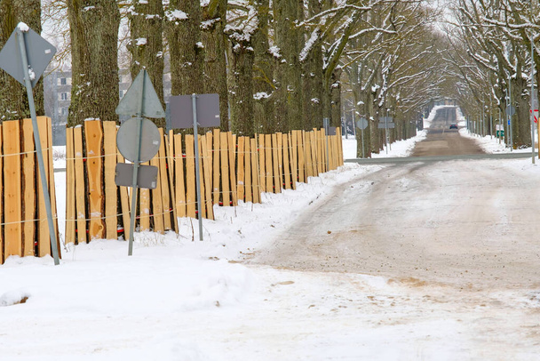 Protección del tronco. Un tronco de árbol cubierto con tablas para protegerse de daños durante una obra cercana. Árboles en el lado de la carretera en la ciudad. - Foto, Imagen