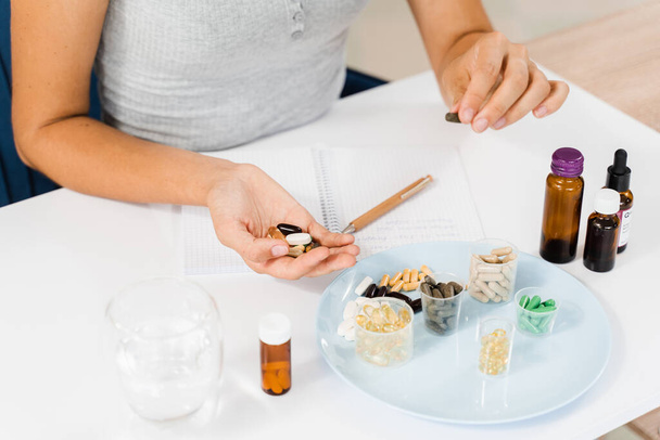 Nutritionist is writing prescription for biologically active supplements omega and zinc pills, antioxidants from aging, lecithin and adaptogen - Fotó, kép