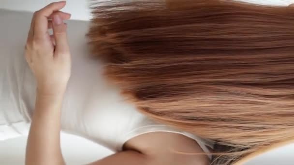 Closeup on a young woman combing her hair - Video