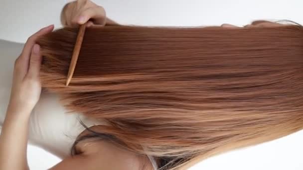 Detailní záběr na mladou ženu česání její vlasy - Záběry, video