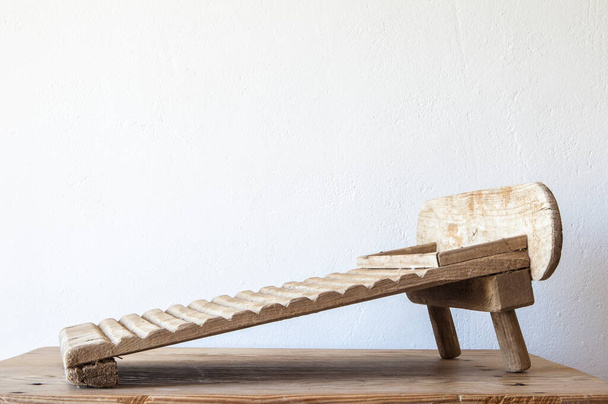 Стара дерев'яна прасувальна дошка. Показується над дерев'яним столом
 - Фото, зображення