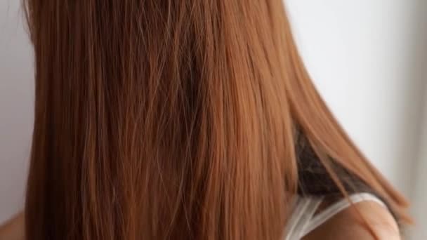 Primer plano de una joven peinándose el pelo - Metraje, vídeo