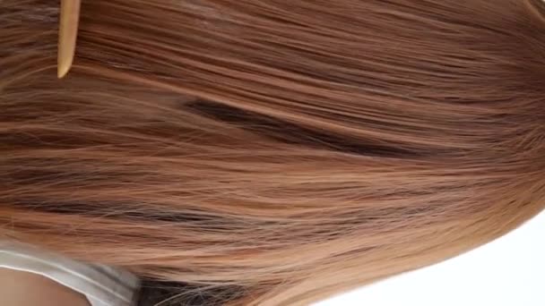 Detailní záběr na mladou ženu česání její vlasy - Záběry, video