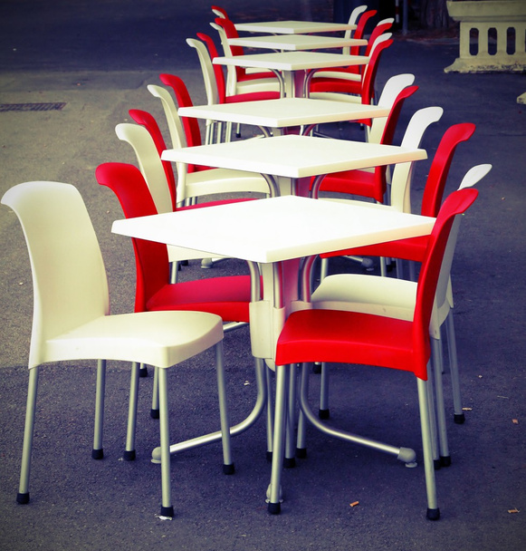 Cadeiras vermelhas e brancas com mesas em um café ao ar livre na estrada
 - Foto, Imagem