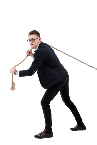 Empresario tirando de una cuerda aislada sobre fondo blanco - Foto, imagen