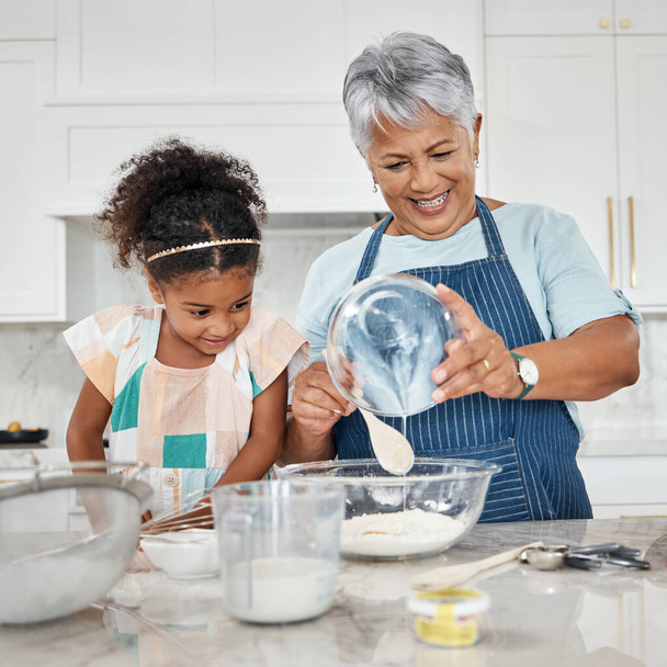 Learning, cooking and grandmother with girl in kitchen mixing milk and flour in bowl. Education, family care and happy grandma teaching child how to bake, bonding and enjoying baking time together - Foto, Bild