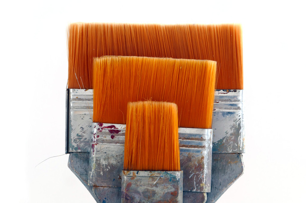 flat brushes with orange bristles, isolated on white background - 写真・画像