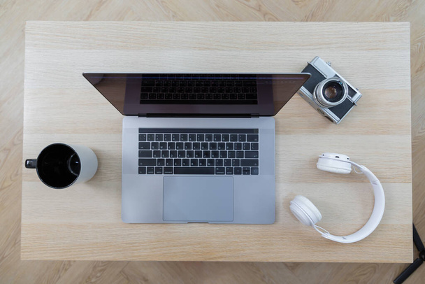 Cuffia con laptop su tavolo in legno su sfondo sfocato. vista dall'alto - Foto, immagini