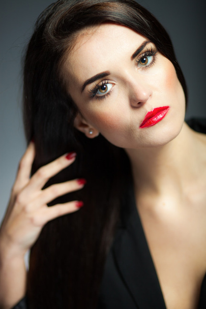 Αίγλη γυναίκα με σκούρα μακριά μαλλιά, κόκκινα χείλη και τα νύχια - Φωτογραφία, εικόνα