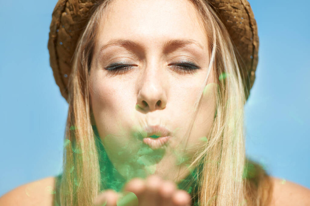 Pomyśl życzenie... piękna młoda kobieta wieje zielony brokat w twoim kierunku - Zdjęcie, obraz