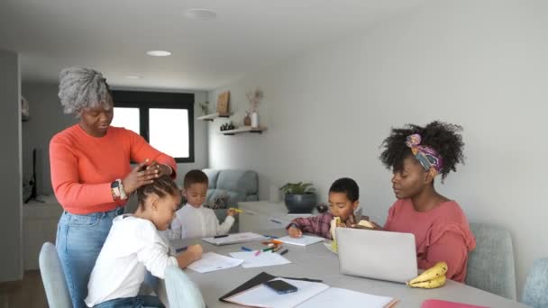 Afrikalı bir aile resim yaparken ya da ödevlerini yaparken atıştırıyor. Yatay olarak genişletilmiş aile birlikte vakit geçiriyor.. - Video, Çekim