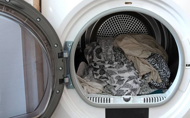 Laundry in the tumble dryer, selective focus - Photo, Image