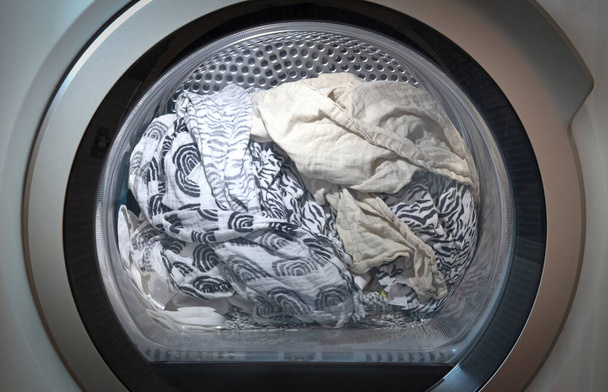 Laundry in the tumble dryer, selective focus - Foto, afbeelding