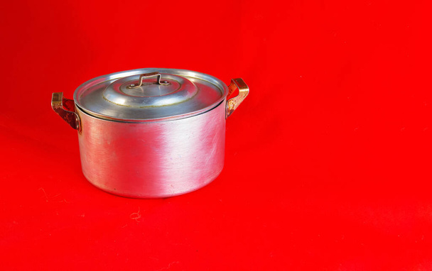 An old aluminum pan made in circa 1960 against a red background. - Foto, imagen