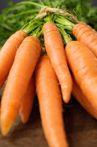 Closeup of carrots on wooden table - Фото, изображение