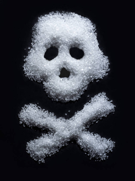 Forme de crâne arrangé à partir de sucre blanc sur fond noir - Photo, image