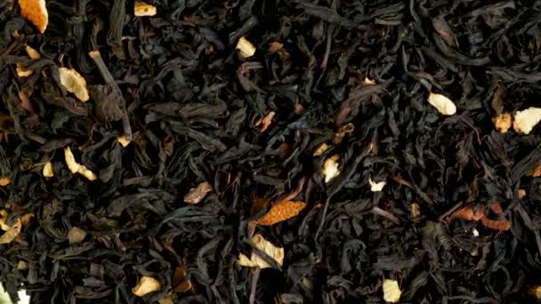 Black tea with orange peel and cinnamon close-up view - Materiał filmowy, wideo