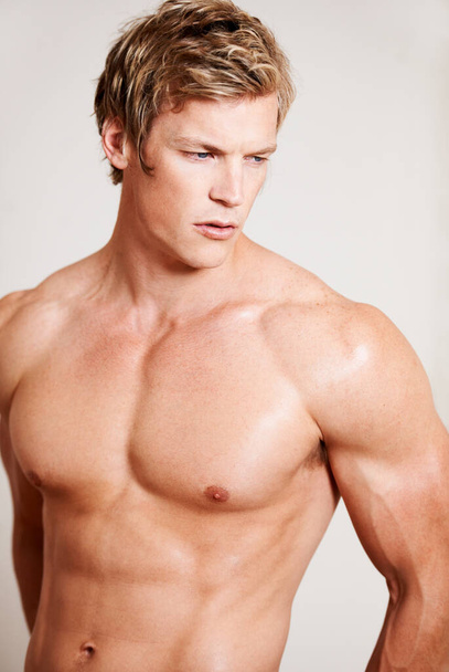 Bis zur Perfektion getrieben. ein muskulöser junger Mann posiert im Studio - Foto, Bild