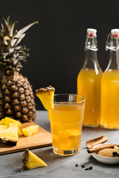 Pineapple Tepache . Homemade Refreshing beverage, lightly fermented drink made from fresh pineapple peel and core, plus brown sugar.High quality photo. Low key. Dark background. - Foto, Bild