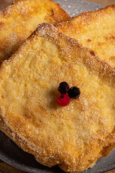 (Torrijas) Fried bread soaked in milk flavored with vanilla, cinnamon and lemon, and egg. Typical Easter sweet. Traditional and festive cuisine concept. Vertical photo and selective focus - Photo, Image