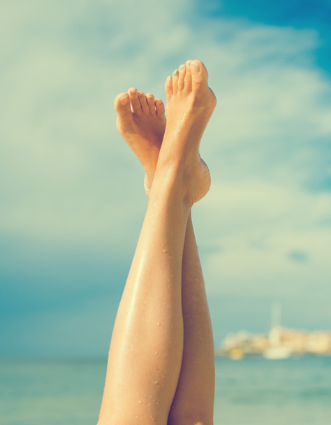 Крупный план женских ног на пляже. - Фото, изображение