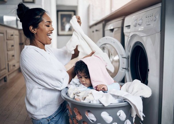Mmm, so soft. a young mother playfully bonding with her baby girl while doing the laundry at home - Fotografie, Obrázek