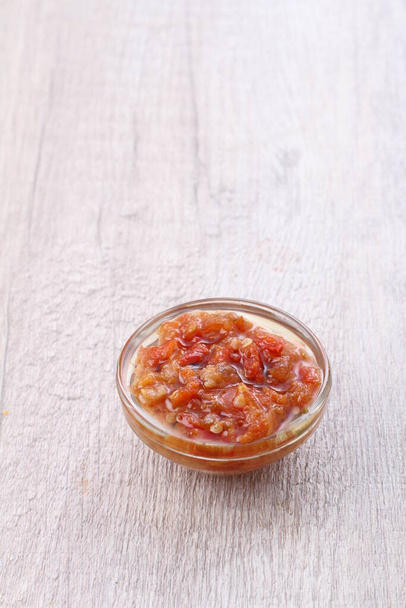 red pepper sauce in a glass bowl on a wooden white background - Fotoğraf, Görsel