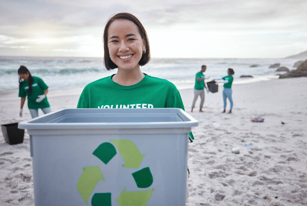 Recycling bin, portrait of Asian woman and volunteer at beach cleaning for environmental sustainability. Recycle, earth day and happy female ready to stop pollution by ocean for community service - Foto, immagini