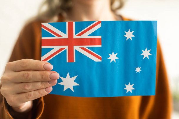 hand holding Australian flag, isolated on white background. - Fotó, kép