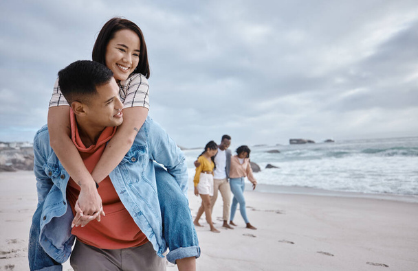 Glücklich, huckepack oder zu zweit an einem Strand in einem erholsamen Urlaub in der Natur. Liebe, Mann und asiatische Frau mit einem Lächeln auf dem Meer genießen Reisen auf Ozeanreisen in Miami, USA. - Foto, Bild