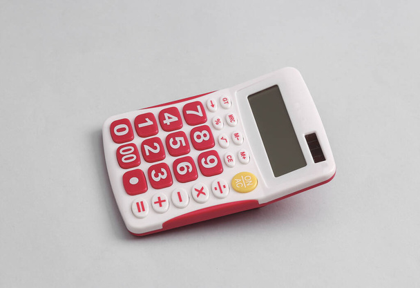 White calculator with pink buttons on a gray background - Foto, Imagen