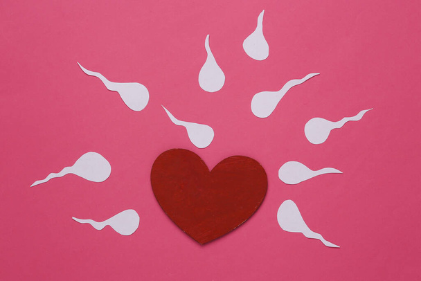Amore, concetto di riproduzione. Semi maschili (spermatozoi) con cuore, fondo rosa - Foto, immagini