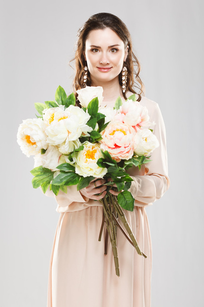 Young beautiful woman with a bouquet of flowers - Photo, Image
