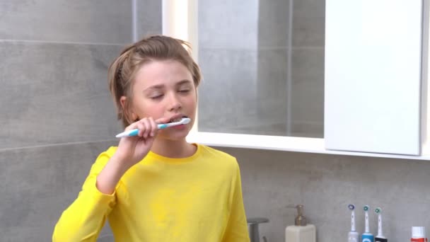 Teenager Boy Brush Teeth Child In Bathroom Looking At Cámara, Odontología, Estomatología, Cuidado dental e higiene con cepillos de dientes, Rutina matutina, Estilo de vida, Cuidado de la salud. - Metraje, vídeo