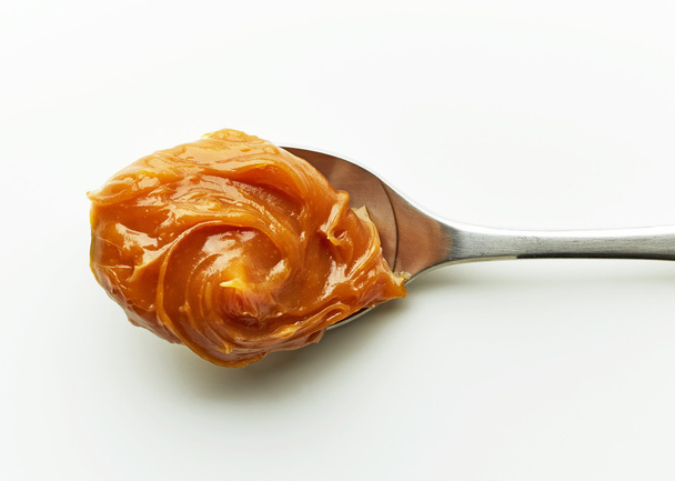 Spoon of melted caramel cream - Photo, Image