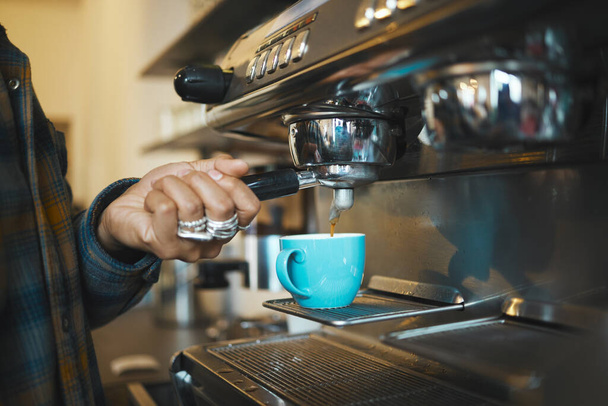 Coffee shop machine handle, hand of barista brewing espresso in restaurant and closeup of hot water beverage in cafe. Caffeine drink in mug, person holding tool on morning in kitchen and breakfast. - Fotografie, Obrázek