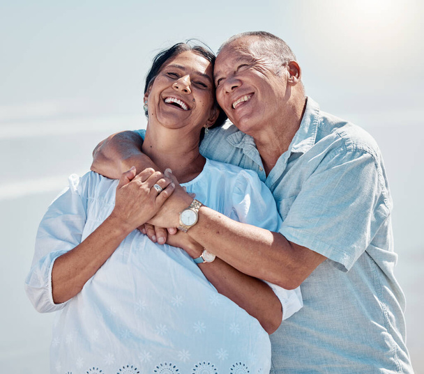 Retirement couple, laughing and hug at beach for love, care and relax on summer holiday, trust or date. Happy senior man, woman and embrace at sea for happiness, support and smile in outdoor sunshine. - Foto, imagen