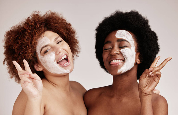 Face mask, peace sign and friends portrait with happiness for sleepover skincare. Wellness, black women smile and spa aesthetic with lotion and moisturizer for facial and cosmetic treatment in studio. - Fotó, kép