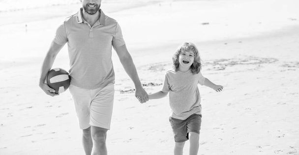 family holidays. sport activity. cropped father and son walking with ball on beach. daddy with kid boy on summer day. weekend family day. dad and child having fun outdoors. childhood and parenting. - Photo, Image