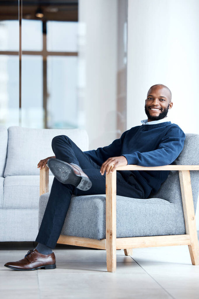 Portrait, black man in office and waiting on chair, smile and confident for job interview, resting and relax. Face, African American male employee and entrepreneur in workplace, happiness and joyful. - Valokuva, kuva