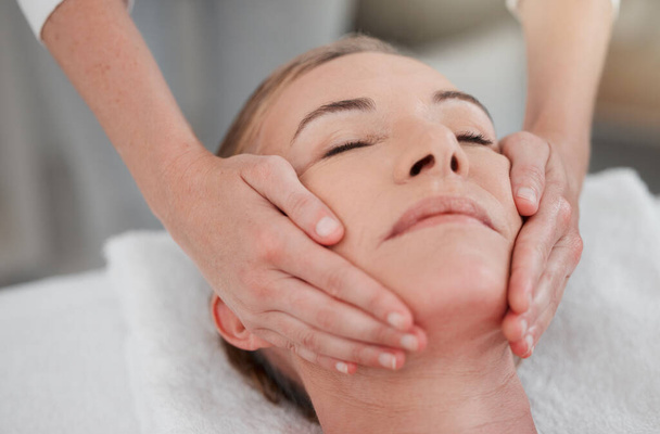 The face has muscles like the rest of the body. a woman receiving a facial massage while at a spa - Foto, imagen