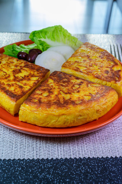 Spanish vegetarian food, portion of homemade tasty potato omelette tortilla de patatas with onion served on terrace in morning sunlights - Fotografie, Obrázek