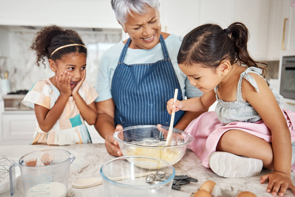 Learning, grandmother and cooking girl in kitchen mixing baking dough in bowl in home. Education, family wow and surprised kid with grandma teaching children how to bake for child development. - Photo, image