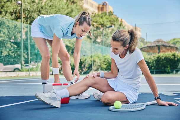 Tennis, medic with first aid and woman with knee pain, torn muscle or inflammation on court while training. Female coach, mentor or help athlete with strain, tender or broken leg with outdoor fitness. - Foto, Bild