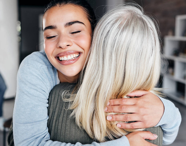 Love, comfort and woman hugging her mother for support, peace or consoling in their family home. Happy, smile and young lady embracing her mature mom with care, happiness and affection at their house. - Foto, afbeelding