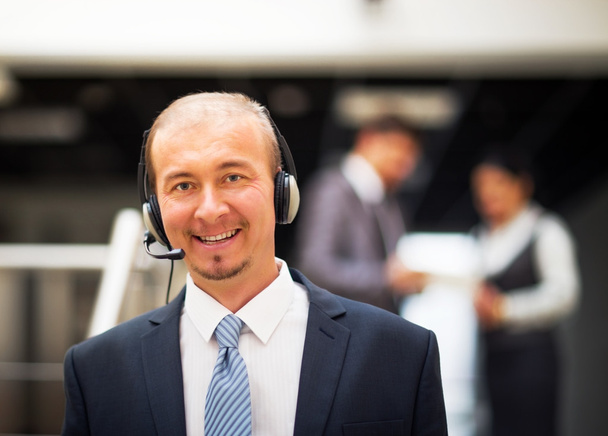 Young customer service operator talking on headset, smiling. - 写真・画像