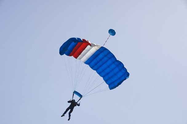 Парашутист стрибає на тлі блакитного неба
 - Фото, зображення